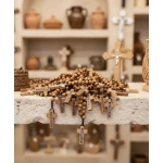 Close-up detail of hand-carved olive wood rosary beads showing grain patterns