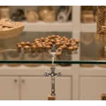 Close-up detail of hand-polished oval olive wood rosary beads with silver-tone metal links