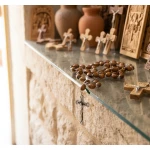 Detail of metal crucifix and centerpiece medal on olive wood metal rosary showing Holy Land craftsmanship