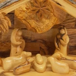 Interior of wooden nativity set barn showing manger scene with nativity figures