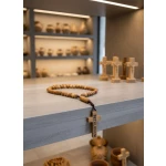 Olive wood rosary displayed on shelf with other bethlehem religious items